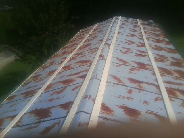 Rusted metal roof panels with new wood purlins before replacement — Storm Damage Roof Repair in Hutto by Roofing Brothers