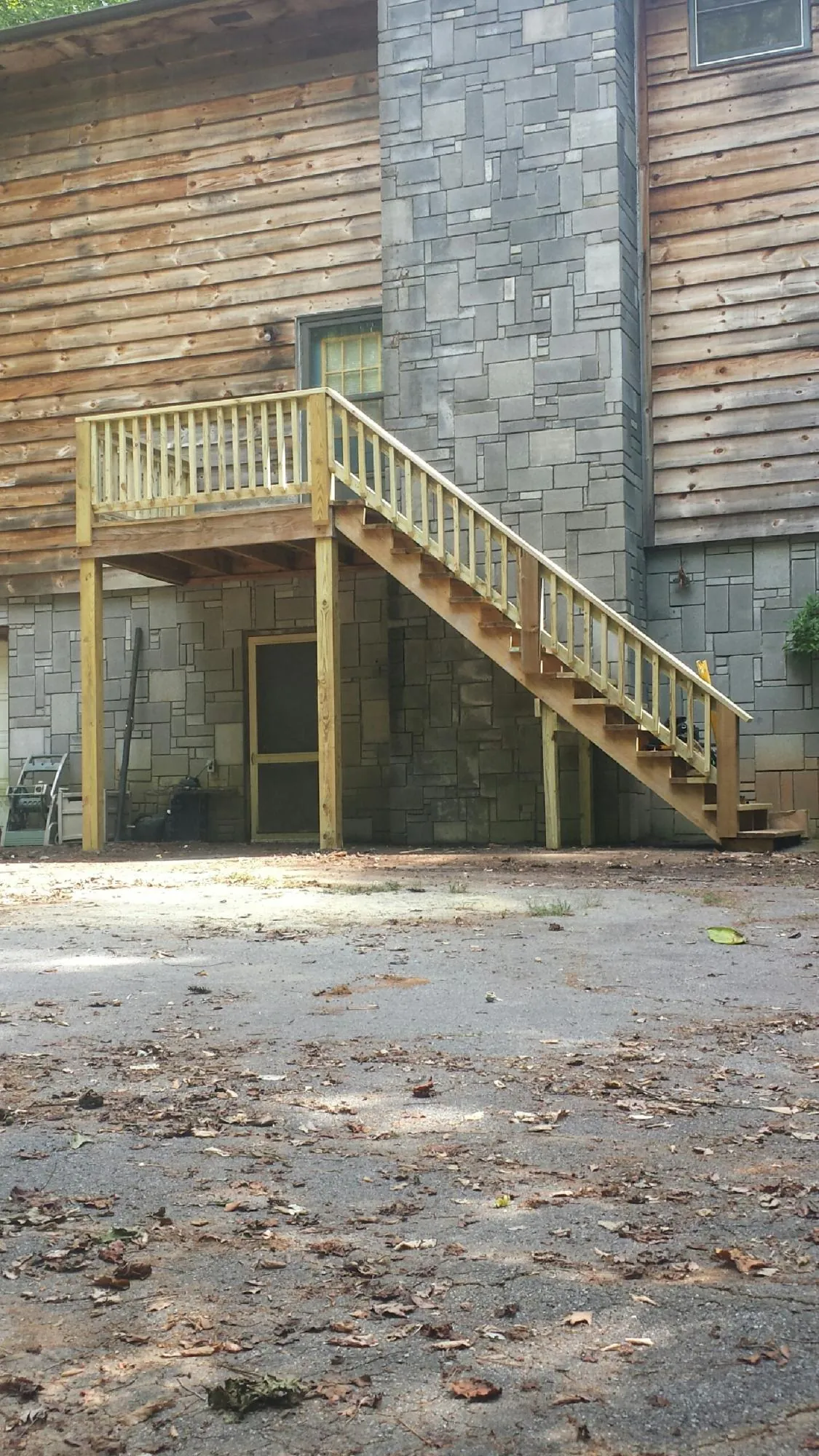 New pressure treated deck and stair landing on a log home in Hutto