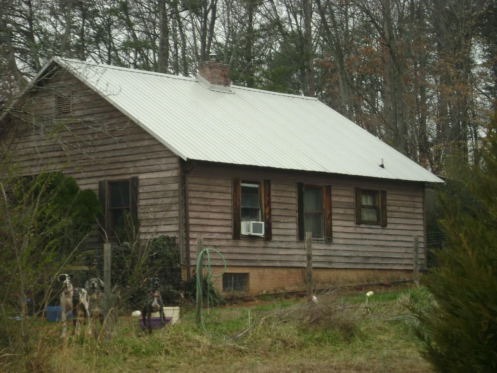 White metal roof on an old wood sided farmhouse, from a Metal Roof Installation job in Hutto